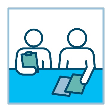 2 people at a desk with documents. 