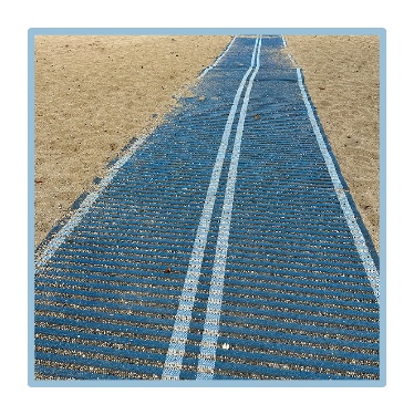 An accessible mat on the sand at the beach. 