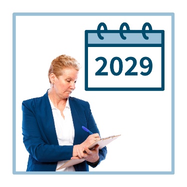 A person writing on a clipboard next to a calendar with '2029' on it. 